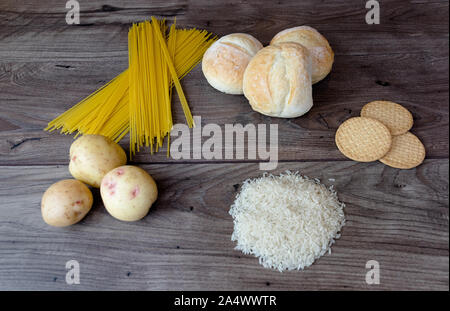 Gemeinsame schlechte Kohlenhydrate zu vermeiden wie weißes Brot, Teigwaren, Reis, Kartoffeln und buscuits Festlegung auf einen hölzernen Tisch von oben gesehen Stockfoto