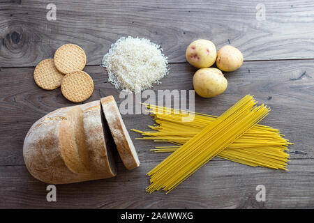 Gemeinsame schlechte Kohlenhydrate zu vermeiden wie weißes Brot, Teigwaren, Reis, Kartoffeln und buscuits Festlegung auf einen hölzernen Tisch von oben gesehen Stockfoto