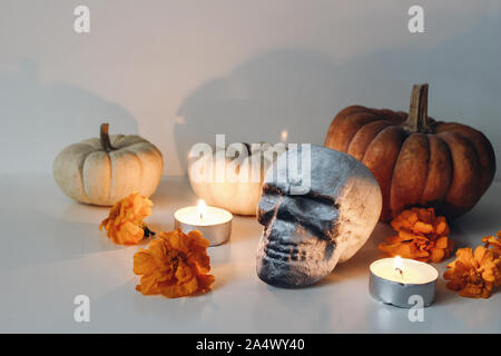 Dia de los Muertos, mexikanischen Tag der Toten Tabelle Altar Komposition. Orange tagetes, Ringelblumen Blumen und menschlichen Künstliche totenkopf dekoration. Brennen Stockfoto