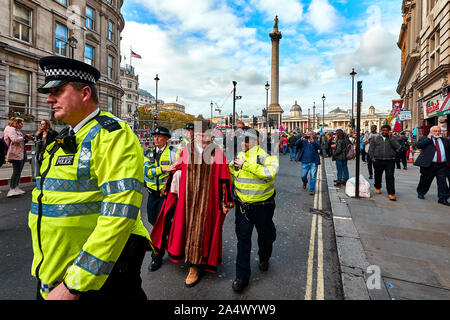 London, Großbritannien - 16.Oktober 2019: Woodbridge Bürgermeister und Grüne Partei Mitglied Eamonn O'Nolan, in bürgerliche Gewänder gekleidet, wird von der Polizei geführt, nachdem für die Sperrung einer Straße in Trafalgar Square, verhaftet zu werden. Stockfoto