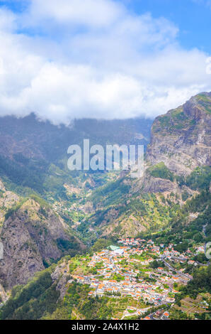 Atemberaubende Curral das Freiras, wie Tal der Nonnen in portugiesischen Madeira bekannt. Kleines Dorf von Felsen und Bergen umgeben. Portugiesische Landschaft. Wolken im Tal. Touristische Attraktion. Stockfoto