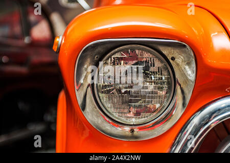 Scheinwerfer Lampe Oldtimer. Classic Car Scheinwerfer. In der Nähe der Scheinwerfer von Orange Oldtimer. Ausstellung. Stockfoto