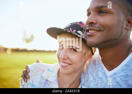 Mixed Race Paar millennials in einem Gras Feld kuscheln und s Stockfoto