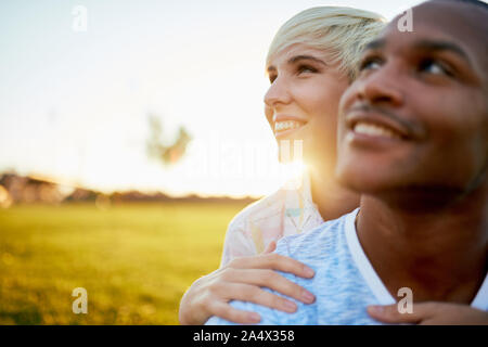 Mixed Race Paar tausendjährigen in eine Rasenfläche, die für eine Stockfoto