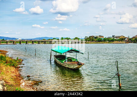 Ein Boot vertäut auf Oi-gawa Fluss vor Togetsu-kyo Bridge, Arashiyama, Kyoto, Japan Stockfoto