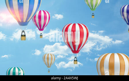 Viele verschieden farbige gestreifte Luftballons fliegen in den bewölkten Himmel. Stockfoto