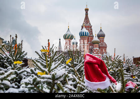 Blick auf die Weihnachtsbäume auf Weihnachtsmarkt und die Basilius-Kathedrale auf dem Roten Platz in Moskau, Russland Stockfoto