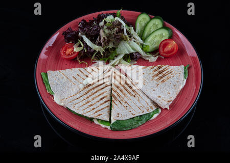 Türkische bazlama tost-gebackenes Brot getoastet mit Gemüse und Bratkartoffeln auf schwarzem Hintergrund serviert. Stockfoto