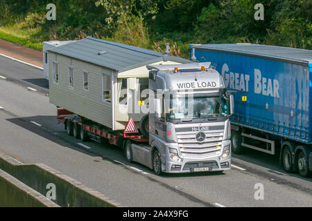 Überholmanschierung mit breiter Ladung mitten auf der Autobahn; Unterkunft beherbergt schwere Großtransporter, Transport, Tieflader, Transport, LKW, Spezialfracht, Mercedes Benz Hi-Line Fahrzeug, Lieferung, Transport, Industrie, statische Caravans Fracht am M6 in Lancaster, Stockfoto