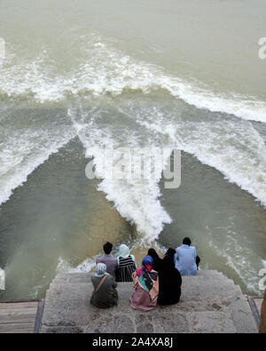 Isfahan, Iran - 1. Mai 2019: Menschen sitzen auf der Khaju Brücke an das ungewöhnliche Ereignis von Wasser unter der Brücke fließt auf der Suche Stockfoto