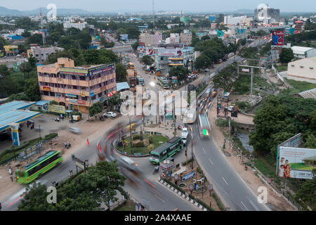 Autos, Busse, Autos und Motorräder, öffentliche Verkehrsmittel Bewegungsunschärfe und Leuchten an einem Kreisverkehr bei Sun in Vellore im September 2019 - Indien Stockfoto