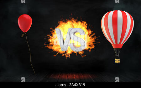 3D-Rendering eines großen flammendes Wort VS zwischen einem roten Luftballon und einem gestreiften Heißluftballon mit einem Korb steht. Stockfoto