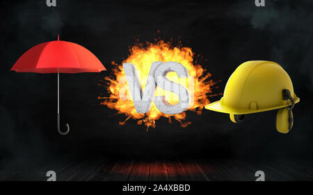 3D-Rendering in großen Buchstaben VS auf Feuer stehen zwischen einem offenen roten Regenschirm und einem großen gelben Bau Helm. Stockfoto