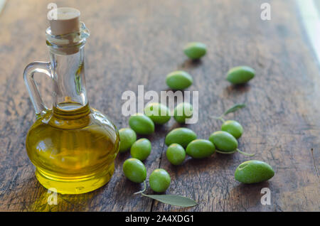 Olivenöl und Beeren sind auf dem hölzernen Tisch Stockfoto