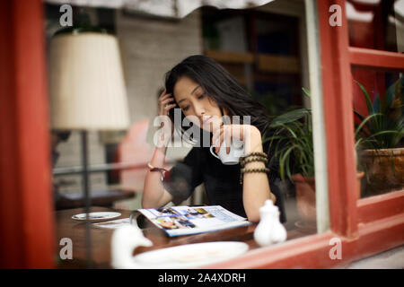 Junge Frau liest in einem Café. Stockfoto