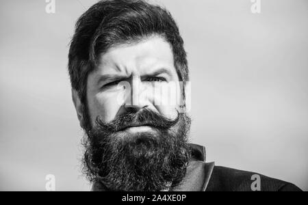 In stilvollen Auftritt investieren. Dicken Bart wachsen schnell. Man bärtige Hipster tragen Anzug und blauer Himmel. Gesichtsbehaarung Bart und Schnurrbart. Bart Fashion Trend. Jeder Bart ist völlig einzigartig. Stockfoto