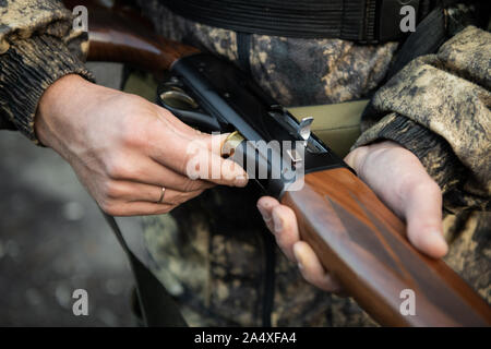 Nahaufnahme eines Jägers Hände seiner Schrotflinte laden. Stockfoto