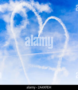 Herzform mit amorpfeil in den Himmel geschrieben mit Rauch Stockfoto
