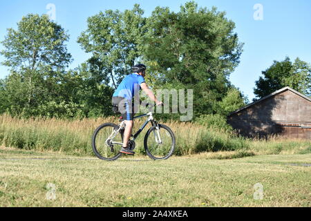 Athleten männlichen Radfahrer Ausübung tragen Helm Reiten Fahrrad Stockfoto