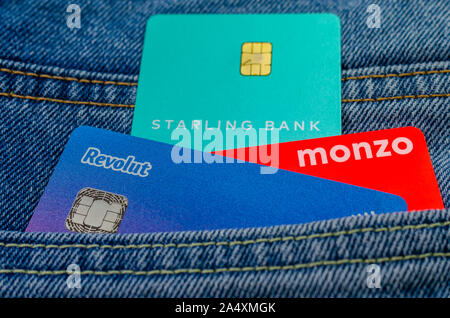 Die Monzo, Revolut und Starling bank Karten kleben aus der gleichen Pocket Jeans. Konzept für einen Wettbewerb in den fin tech Markt. Stockfoto