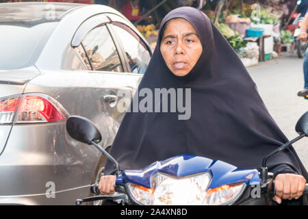 Mae Sot, Thailand - 3. Februar 2019: muslimische Frau Motorrad fahren. Motorräder sind eine gemeinsame für die von privaten Verkehrsmitteln. Stockfoto