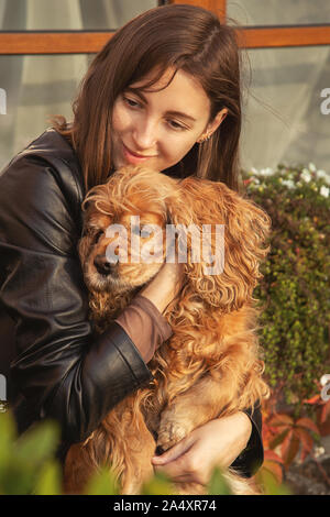 Frau mit American Cocker Spaniel sitzend Umarmungen Stockfoto