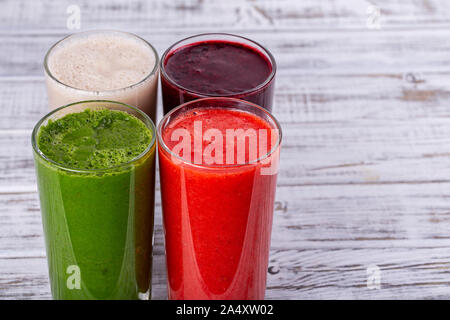 Frische Avocado, Erdbeere, Heidelbeere und Bananen Smoothie auf weissem Holztisch. Gesunde Cocktails mit frischem Obst. Schließen Sie bis zu vier Getränke, Kopie Raum Stockfoto