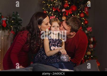 Freundliche Familie feiert Weihnachten. Wohnzimmer in hellen Weihnachtsbeleuchtung. Urlaub Dekorationen. Winter Weihnachten zusammen. Frohes neues Jahr. Stockfoto