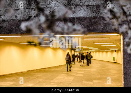 Menschen zu Fuß durch einen unterirdischen Tunnel in Budapest mit weißen Cherry verschwommen Blüten auf einen Vordergrund. Stockfoto