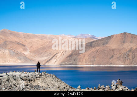 Eine Frau stand vor der Pangong See mit Berge und blauer Himmel Hintergrund Stockfoto