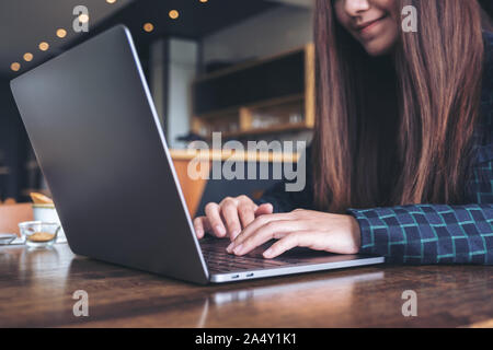 Closeup Bild der Hände eines Business woman Arbeiten und Schreiben auf Laptop Tastatur auf hölzernen Tisch Stockfoto