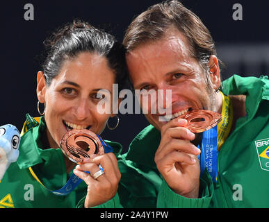 Doha, Katar. 16 Okt, 2019. Bronze- medaillengewinner Cortez Joana (L)/Font Vinicius von Brasilien posieren für Fotos, die während der Verleihung des gemischten Doppel Beach Tennis am 1. ANOC Welt Spiele am Strand Katar 2019 in Doha, der Hauptstadt von Katar, Okt. 16, 2019. Credit: Nikku/Xinhua/Alamy leben Nachrichten Stockfoto