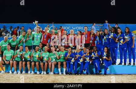 Doha, Katar. 16 Okt, 2019. Goldmedaillenträger Spieler von Dänemark (in Rot), silbermedaillengewinner Spieler von Ungarn (in grün) und Bronze medaillenträger Spieler in Brasilien (in Blau) feiern bei der Verleihung des Women's Beach Handball am 1. ANOC Welt Spiele am Strand Katar 2019 in Doha, der Hauptstadt von Katar, am Okt. 16, 2019. Credit: Nikku/Xinhua/Alamy leben Nachrichten Stockfoto