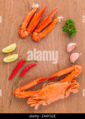 Gekochte Krabben mit Limettensaft, Chili, Knoblauch und Petersilie auf Holz- Hintergrund. Stockfoto