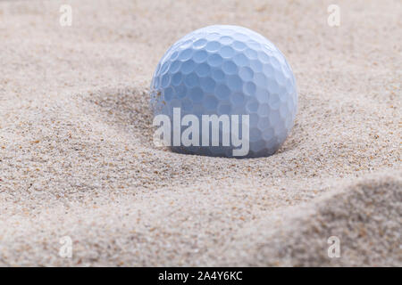 Golfball im Sandbunker geringe Schärfentiefe hautnah. Stockfoto