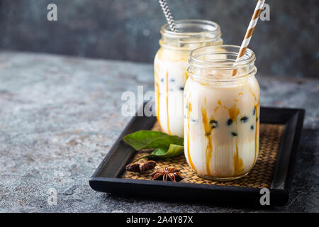 Hellbraun cremige bubble Tee mit Milch und schwarz Tapioka in einem Glas auf grauem Hintergrund Stockfoto