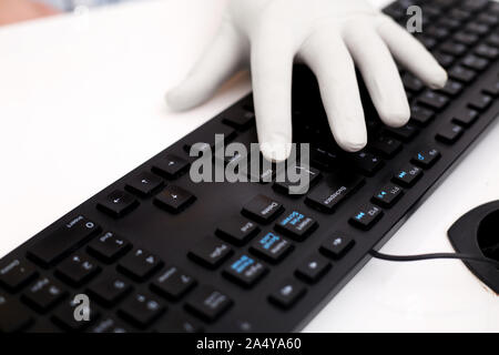 Bild der Mann mit der Eingabe mit Tastatur und tragen Handschuhe getragen. Auf weissem Hintergrund. Stockfoto