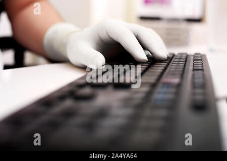 Bild der Mann mit der Eingabe mit Tastatur und tragen Handschuhe getragen. Auf weissem Hintergrund. Stockfoto