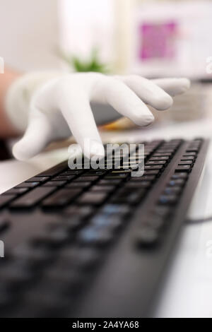 Bild der Mann mit der Eingabe mit Tastatur und tragen Handschuhe getragen. Auf weissem Hintergrund. Stockfoto