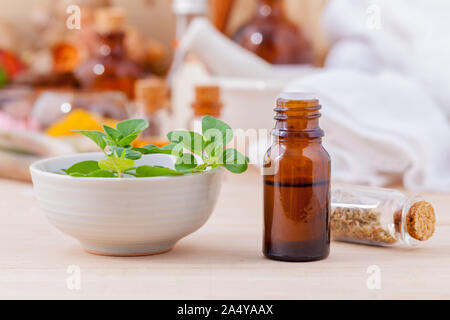 Natural Spa Inhaltsstoffe Ätherisches Öl mit Oregano Blätter für die Aromatherapie setup auf Spa Zutaten Hintergrund. Stockfoto