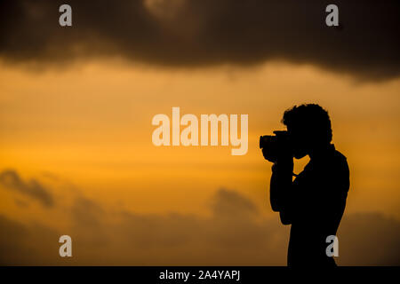 Die Silhouette eines Fotografen einem Sonnenaufgang, Stockfoto