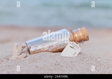 Sand und Muschel in der Flasche am Strand Konzept für die hochzeit einladung oder Hochzeit Geschenk Veranstaltungsort auf den Strand. Stockfoto