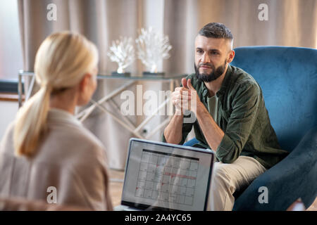 Dark-eyed Mann besser Gefühl beim Gespräch mit dem Psychologen Stockfoto