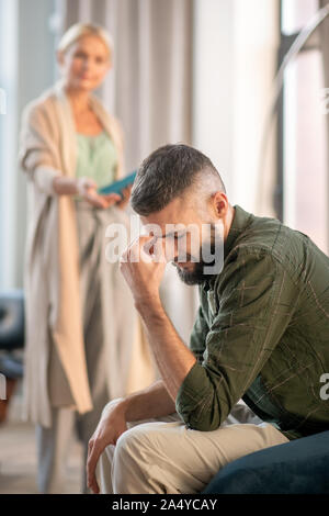 Bärtiger Mann Gefühl umgekippt beim Sprechen mit psychoanalytiker Stockfoto