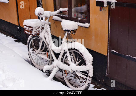 Snowy altes Fahrrad auf einem winter Februar Straße, einer alten Europäischen Stadt vergessen Stockfoto