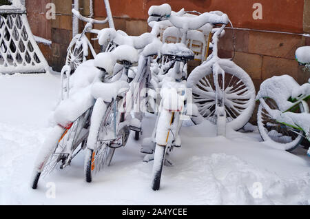 Verschneite alte Fahrräder auf einem winter Februar Straße, einer alten Europäischen Stadt vergessen Stockfoto