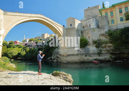 MOSTAR, BOSNIEN UND HERZEGOWINA - 21. SEPTEMBER 2019: Die alte Brücke (Stari Most), von den Ufern des Flusses Neretva gesehen Stockfoto