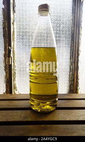 Flasche frisches Olivenöl mit Hintergrundbeleuchtung gegen alte Dorf Haus Fenster, Galatas, Kreta, Griechenland Stockfoto