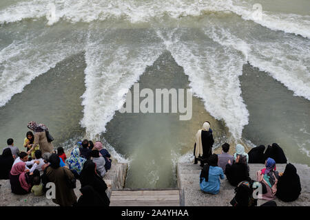 Isfahan, Iran - 1. Mai 2019: Menschen sitzen auf der Khaju Brücke an das ungewöhnliche Ereignis von Wasser unter der Brücke fließt auf der Suche Stockfoto