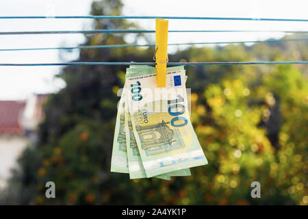 Euro-banknoten hängen mit Wäscheklammer auf der Wäscheleine. Geldwäsche Geschäftskonzept. Abstrakte konzeptuelle Bild Stockfoto
